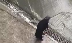 Taşkın oluşmaması için bastonu ile mazgaldaki yaprakları temizledi